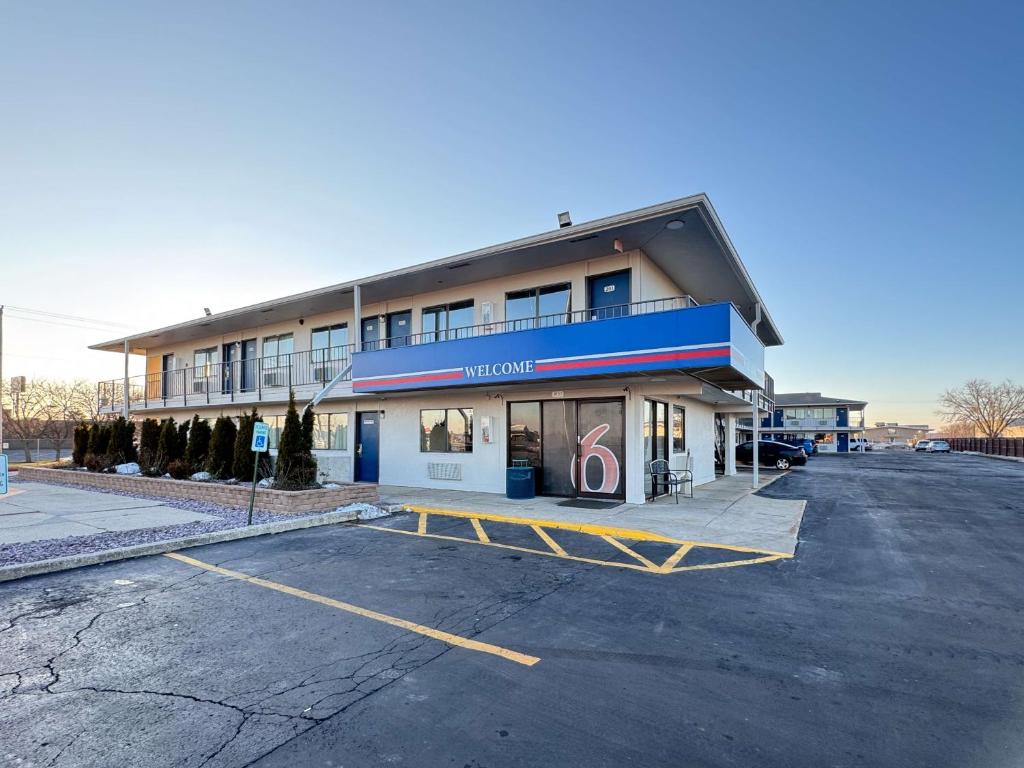 un edificio con un estacionamiento delante de él en Motel 6-Janesville, WI, en Janesville