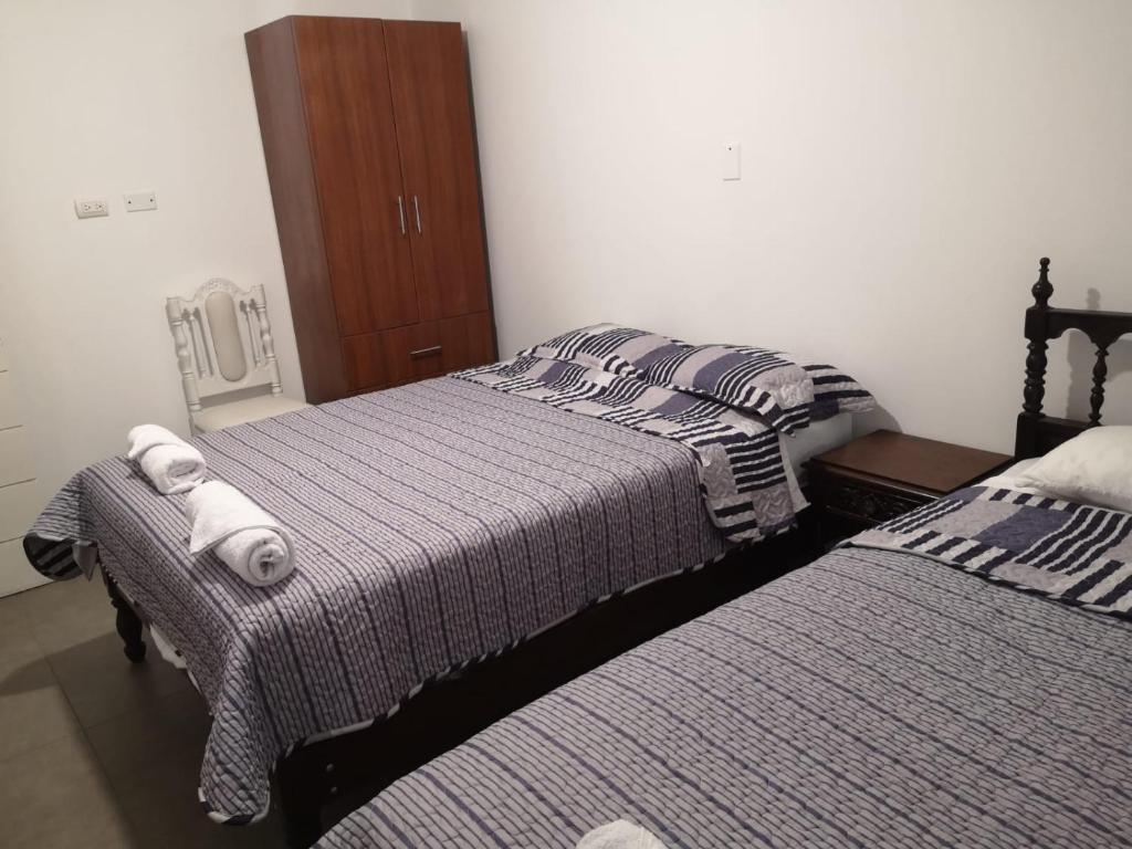 Dos camas en una habitación de hotel con toallas. en Chimor House, en Huanchaco