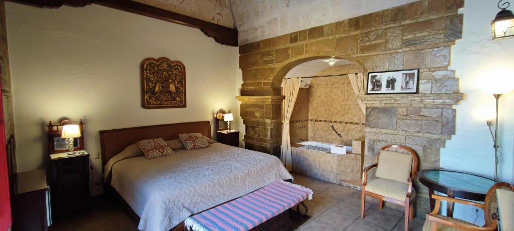 a bedroom with a bed and a stone wall at Flying Dog Hostel Arequipa in Arequipa