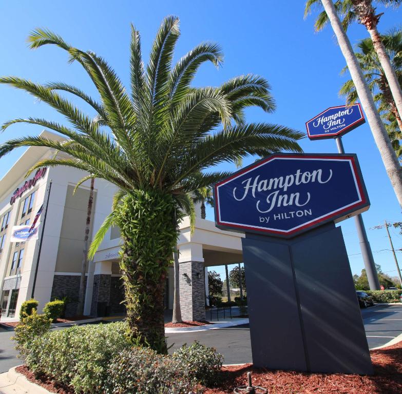 um sinal para uma estalagem Hampton em frente a uma palmeira em Hampton Inn Saint Augustine-I-95 em Saint Augustine