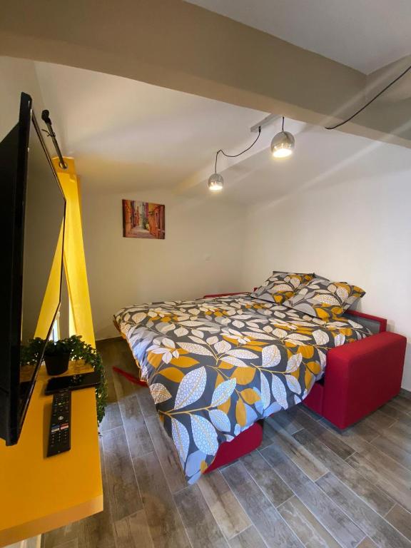 a bedroom with a bed and a flat screen tv at Coquet Studio Cœur de Grasse in Grasse