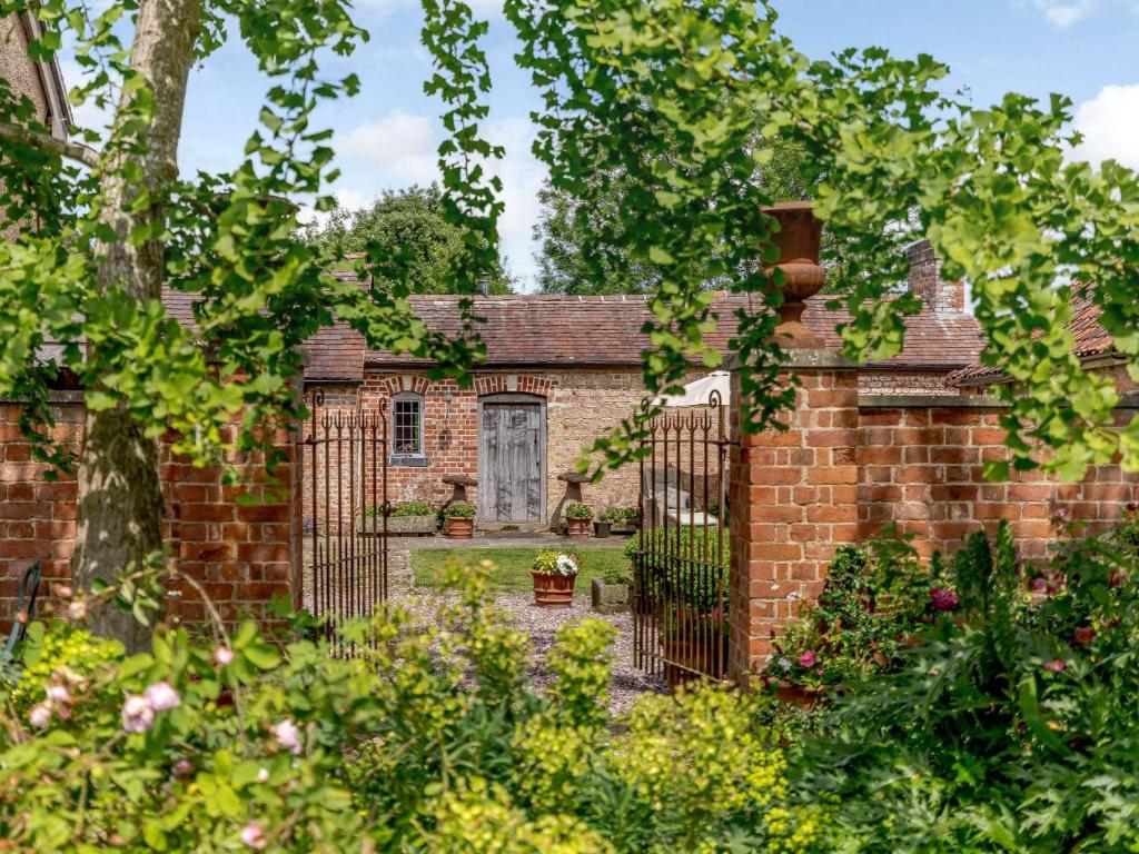 an old brick house with a gate in a garden at 1 Bed in Gloucester 46502 in Lassington