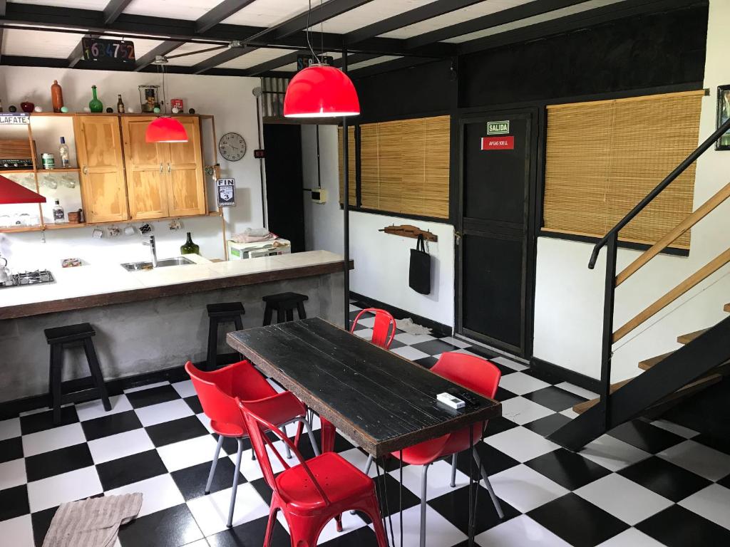 een keuken met een tafel en rode stoelen bij CASA 2 AGUAS MELINCUÉ in Melincué