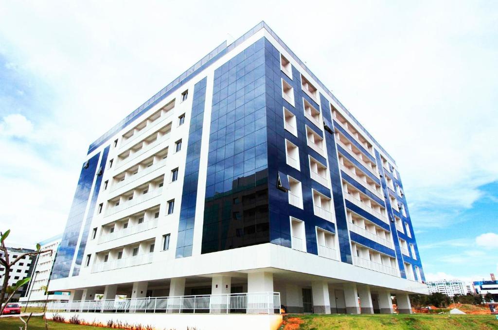 a large building with blue windows on the side of it at Noroeste Atrium Platine Apartamento Completo in Brasilia