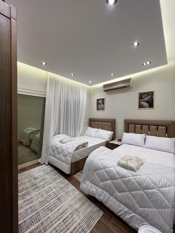 a bedroom with two beds and a mirror at DownTown New Cairo in Cairo