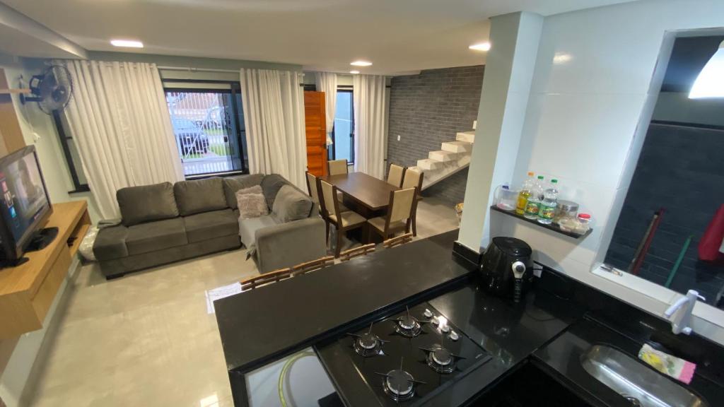 a kitchen and living room with a stove and a couch at Triplex novo em Matinhos litoral Paraná in Matinhos