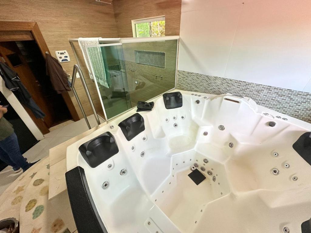a bathroom with a white tub and a shower at Casa Amarela in Paranoá