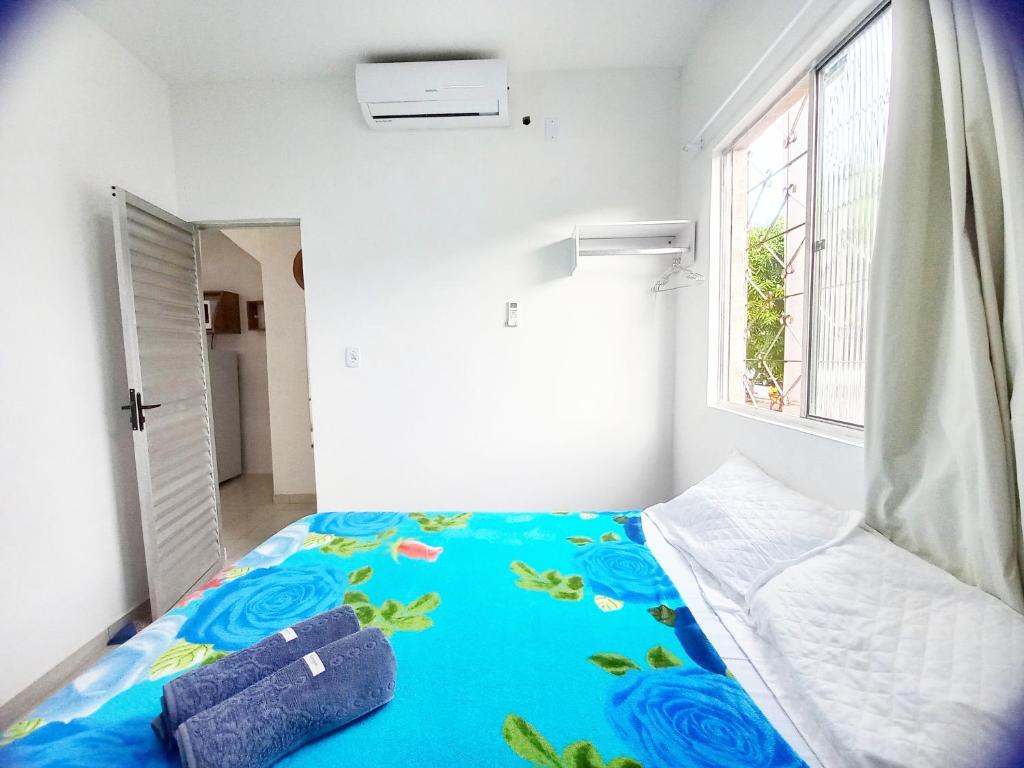 um quarto com uma cama com um cobertor azul em Mar.6: spacious 1 room, 2 AC, near Airport and Stella Maris beach em Salvador