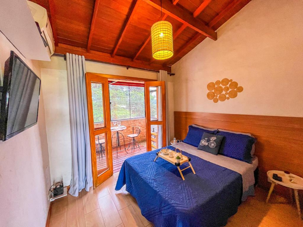 ein Wohnzimmer mit einem Bett und einem Tisch in der Unterkunft Ap Encontro dos Sonhos in Carrancas