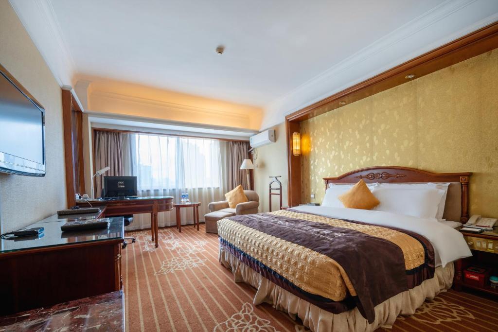 a hotel room with a bed and a desk at Sunshine Holiday Hotel Fuzhou in Fuzhou