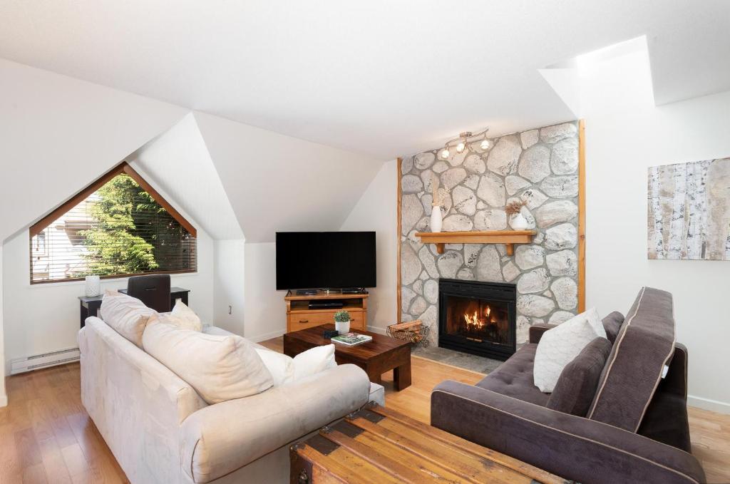 a living room with a couch and a fireplace at Gleneagle 29 - Townhome near Golf Course with Balcony, BBQ - Whistler Platinum in Whistler