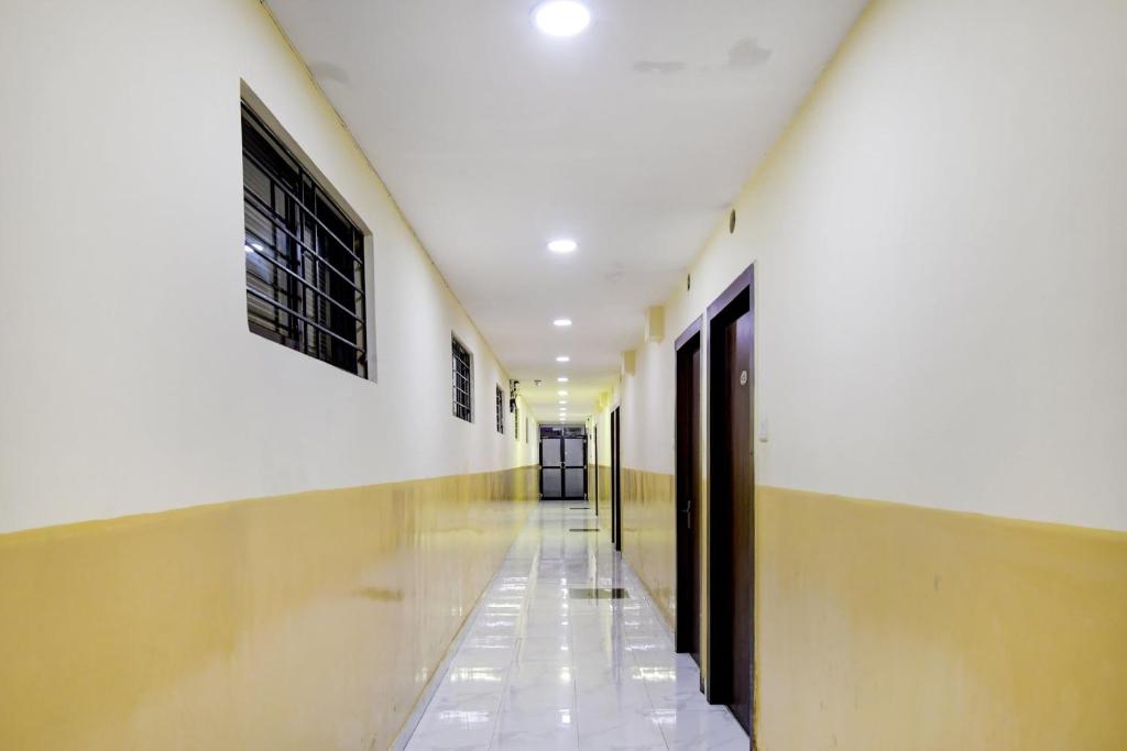 un pasillo de un edificio con paredes y techos blancos en Kyd Guest House Near Indian Museum en Calcuta