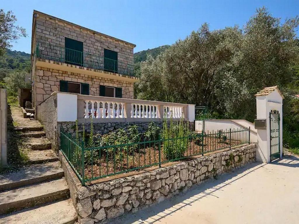 ein Backsteinhaus mit einem Zaun und einer Steinmauer in der Unterkunft Apartments by the sea Prozurska Luka, Mljet - 22338 in Prožura