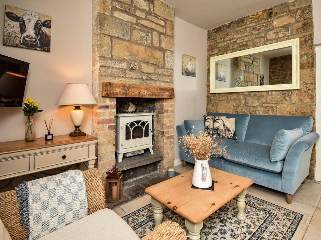 salon z niebieską kanapą i kominkiem w obiekcie 1 Bed in Rothbury 88286 w mieście Rothbury