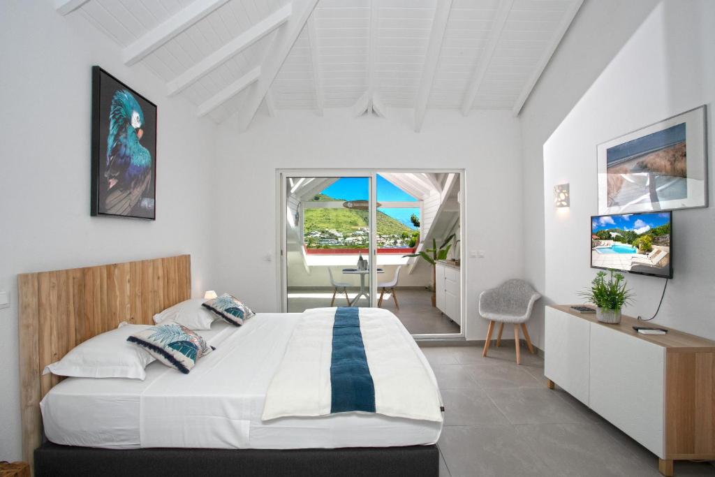 Schlafzimmer mit einem Bett, einem Tisch und Stühlen in der Unterkunft Beautiful suite S12 with pool and sea view in Cul de Sac