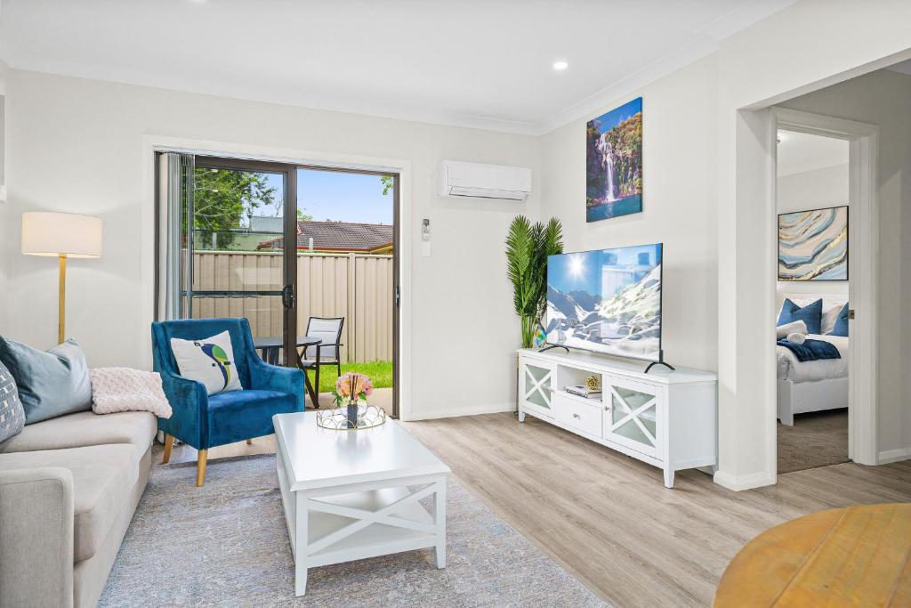 a living room with a couch and a tv at Charming 2-Bed Moss Vale Getaway in Moss Vale