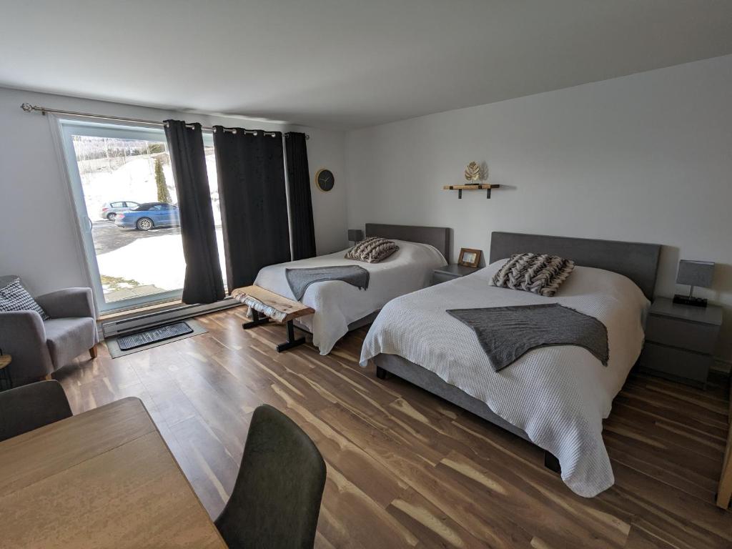 a bedroom with two beds and a table and a couch at Bienvenue chez Alice et daniel in Saint-Férréol-les-Neiges