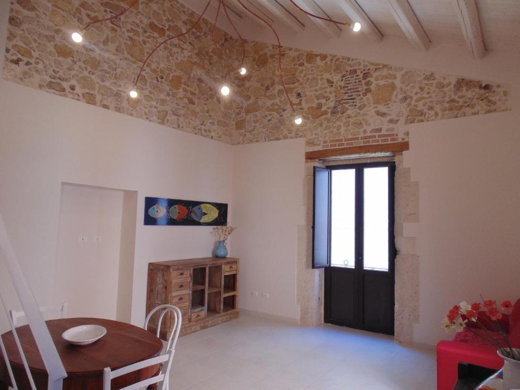 ein Wohnzimmer mit einem Tisch und einem Fenster in der Unterkunft Allegrakori in Syrakus