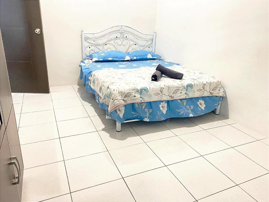 Schlafzimmer mit einem Bett mit blauer Decke in der Unterkunft HOMESTAY NAFISAH in Tapah Road