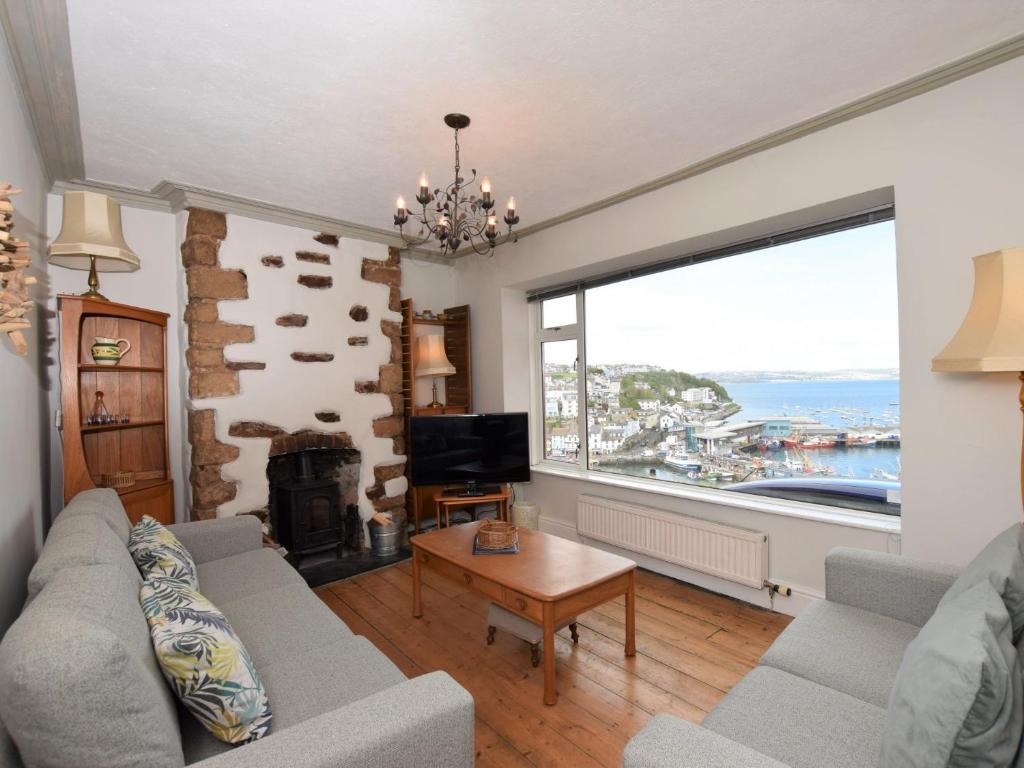 a living room with a fireplace and a large window at 3 bed property in Brixham BX045 in Brixham