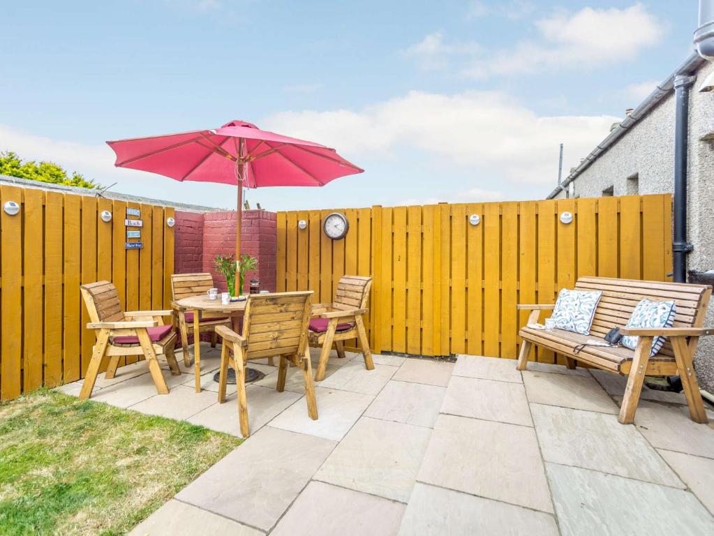 a patio with a table and chairs and an umbrella at 2 Bed in Boulmer 60464 in Boulmer