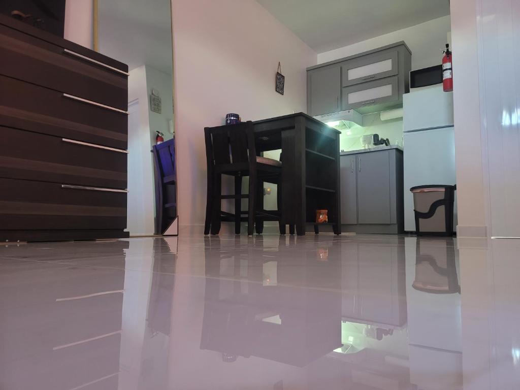 una cucina con tavolo e sedia su un pavimento piastrellato di Vadi's Lux, Wi-fi, coffe, tea, parking, laundry room. a Mayaguez