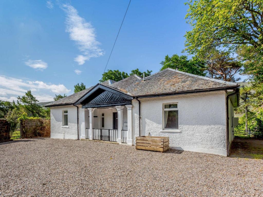 a white house with a gravel driveway at 5 Bed in Achnasheen 83017 in Achnasheen