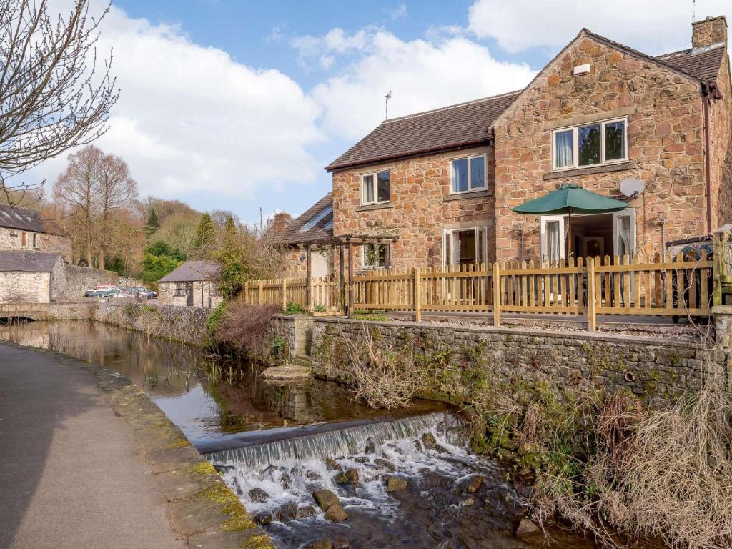 a stone house with a bridge over a river at 4 Bed in Bakewell PK911 in Bakewell