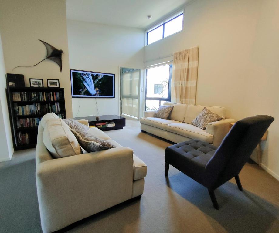 uma sala de estar com dois sofás e uma cadeira em Mount Stunner with King Beds em Mount Maunganui