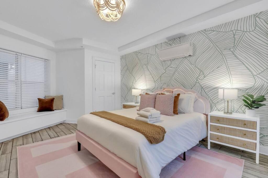 una camera con un letto rosa e bianco e una finestra di Salt & Sea Inn Unit A-1 Bed 1 Ba Condo w/Pool a Tybee Island