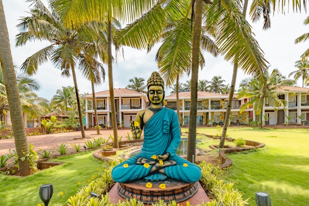 a statue in front of a resort with palm trees at Nilaya Stays in Padubidri