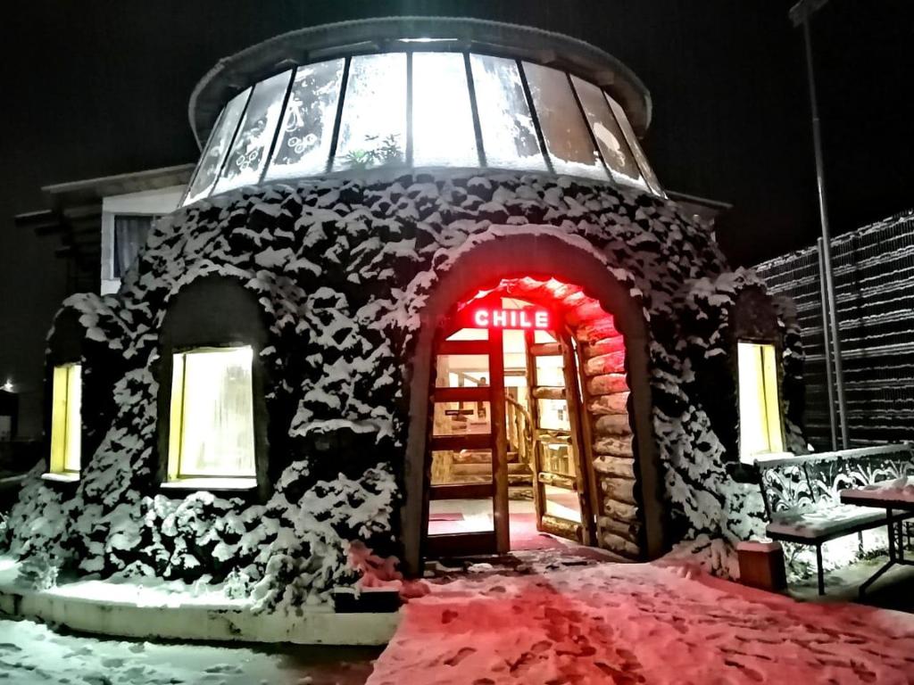 un edificio de pan de jengibre con una puerta roja en la nieve en Hotel Catripulli, en Pucón