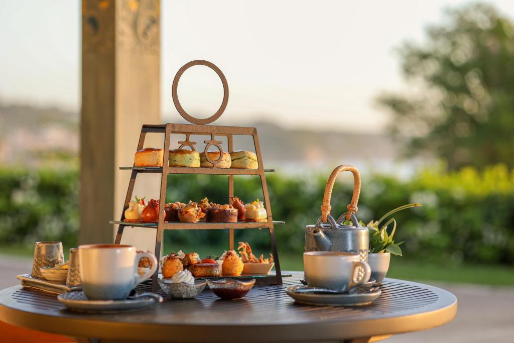 a tray of pastries and cups on a table at Jumeirah Bali in Uluwatu