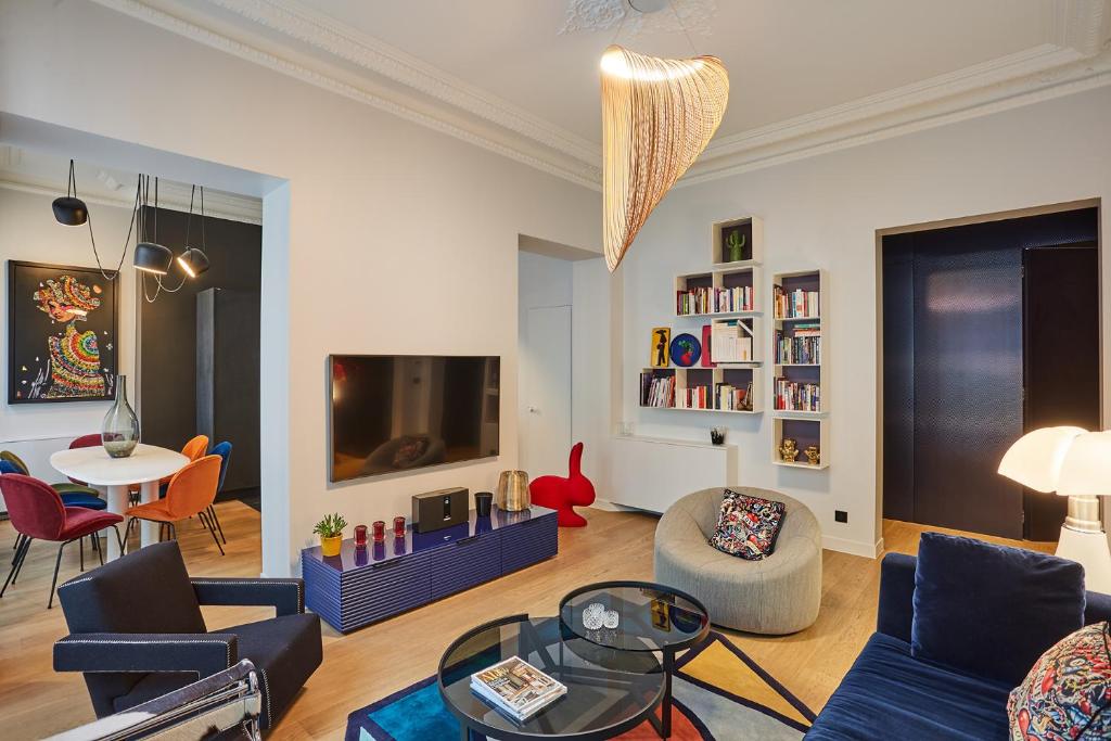 a living room with a blue couch and a tv at Designer luxury flat in Central Paris - 2bed 2bath with AC in Paris