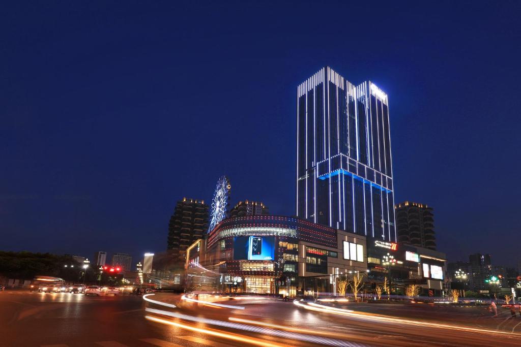a tall building at night with traffic in a city at CYNN XANADU Hotel Chengdu in Chengdu