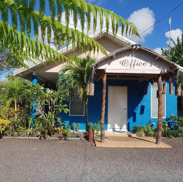 une maison bleue avec un panneau indiquant le bureau dans l'établissement LE RIC HOUSING LTD, à Apia