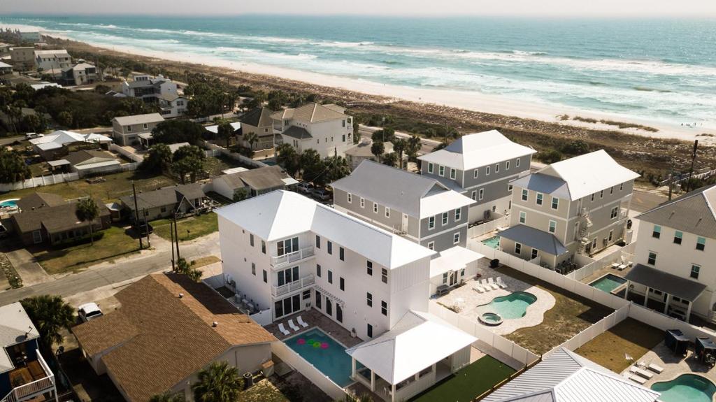 eine Luftansicht auf ein weißes Gebäude neben dem Strand in der Unterkunft The Taj Of The Gulf! Luxury Beach Mansion! Sleeps 37, private pool & hot tub, putting golf in Panama City Beach