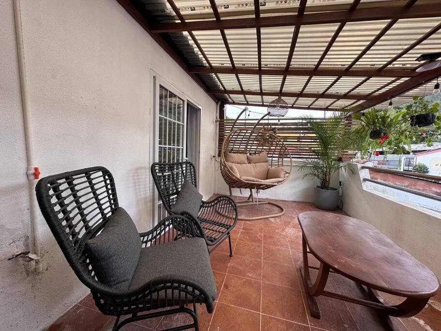 a porch with chairs and a table and a table at Casa Geranios Antigua in Antigua Guatemala
