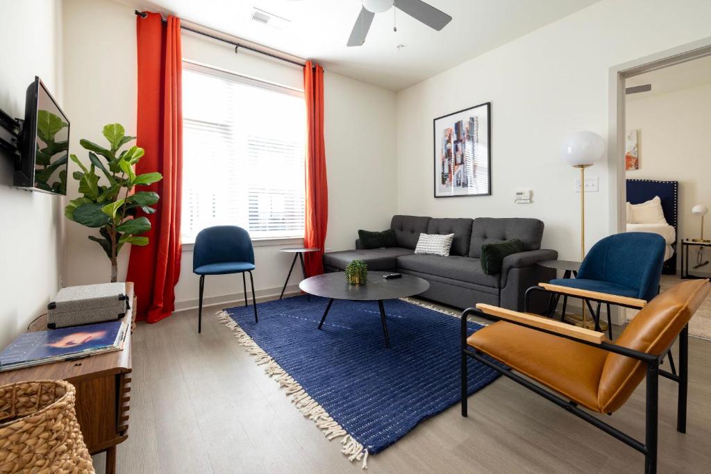 a living room with a couch and a table and chairs at Modern Nulu 2BR CozySuites 05 in Louisville