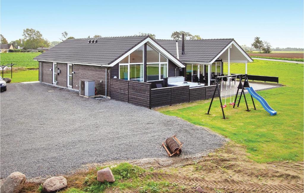 a house with a playground in front of it at Amazing Home In Bogense With Sauna in Bogense