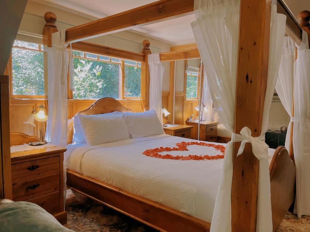 Arnica Views Summit Retreat في ماونت داندينونج: غرفة نوم بسرير كبير مع اطار خشبي