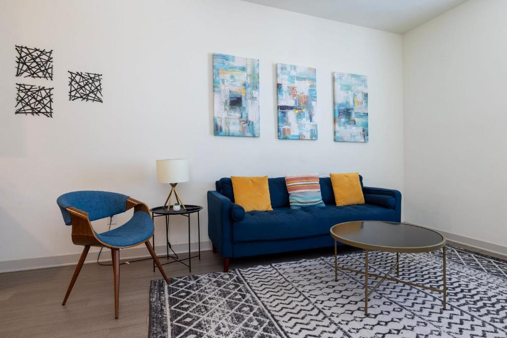 a living room with a blue couch and two chairs at Stunning Nulu 1BR CozySuites 06 in Louisville