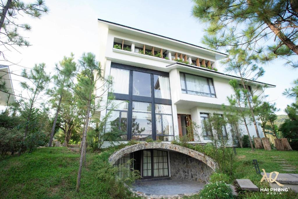 uma grande casa branca com muitas janelas em AQ Story Villa Vĩnh Phúc em Phúc Yên