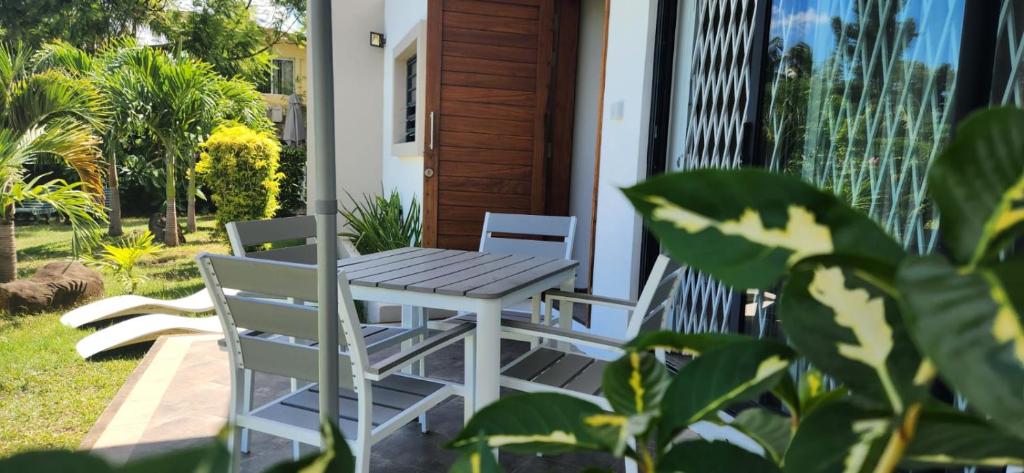 een tafel en stoelen op de veranda van een huis bij La Maison d'Isa in Albion