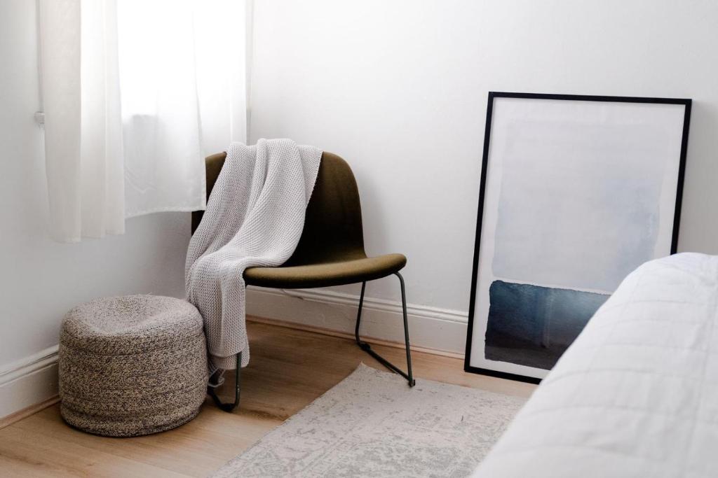 een stoel met een deken en een kruk in een slaapkamer bij Your home on Smith St Collingwood (With Parking) in Melbourne