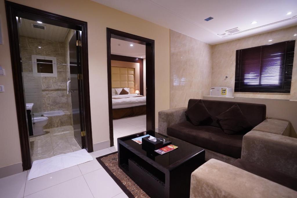 un salon avec un canapé et une salle de bains. dans l'établissement Hotel and Apartments Al Raqi Mall Artiaad, à Tabuk