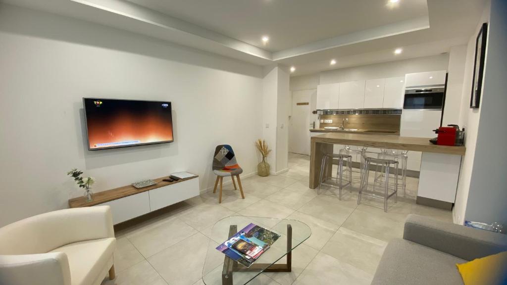 ein Wohnzimmer mit einem Sofa und einem Tisch in der Unterkunft Superbe Appartement Hypercentre climatisé in Cannes