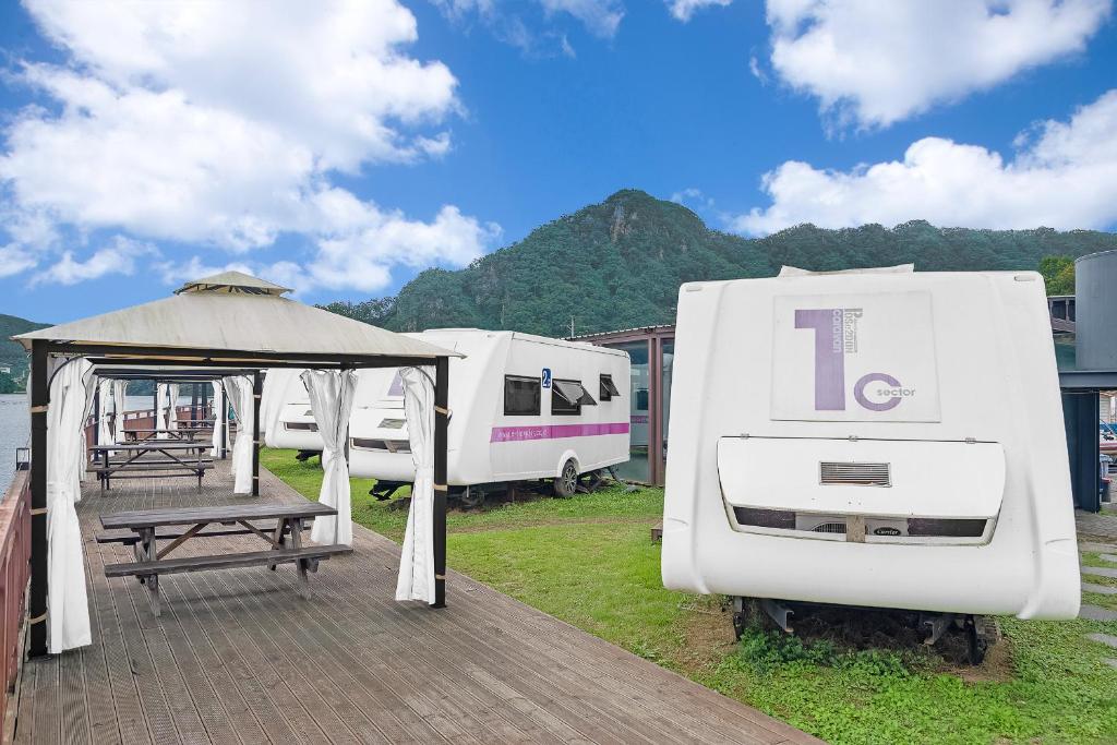 a group of white rvs parked on a deck at Poseidon Caravan in Gapyeong