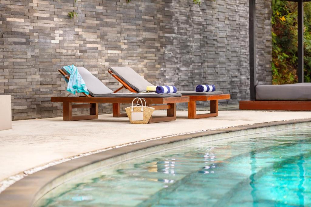 a pool with a table and chairs next to a swimming pool at The Terraces Boutique Apartments in Port Vila