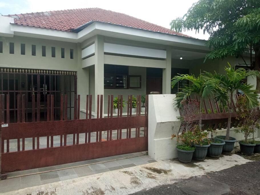 una casa con una valla y plantas delante de ella en Homestay Mutiara en Yogyakarta